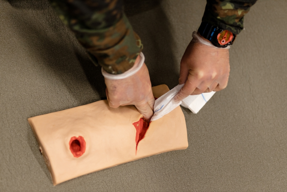 A,Military,Medic,Practices,Stopping,Bleeding,On,A,Wounded,Mannequin.